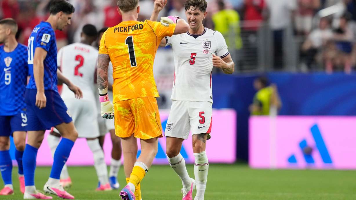 England's John Stones (5) and England goalkeeper Jordan Pickford (1) celebrate their team's fourth goal by England's Marcus Rashford during the World Cup Group L soccer match between England and Croatia in Arlington, Texas, near Dallas, Wednesday, June 17, 2026.