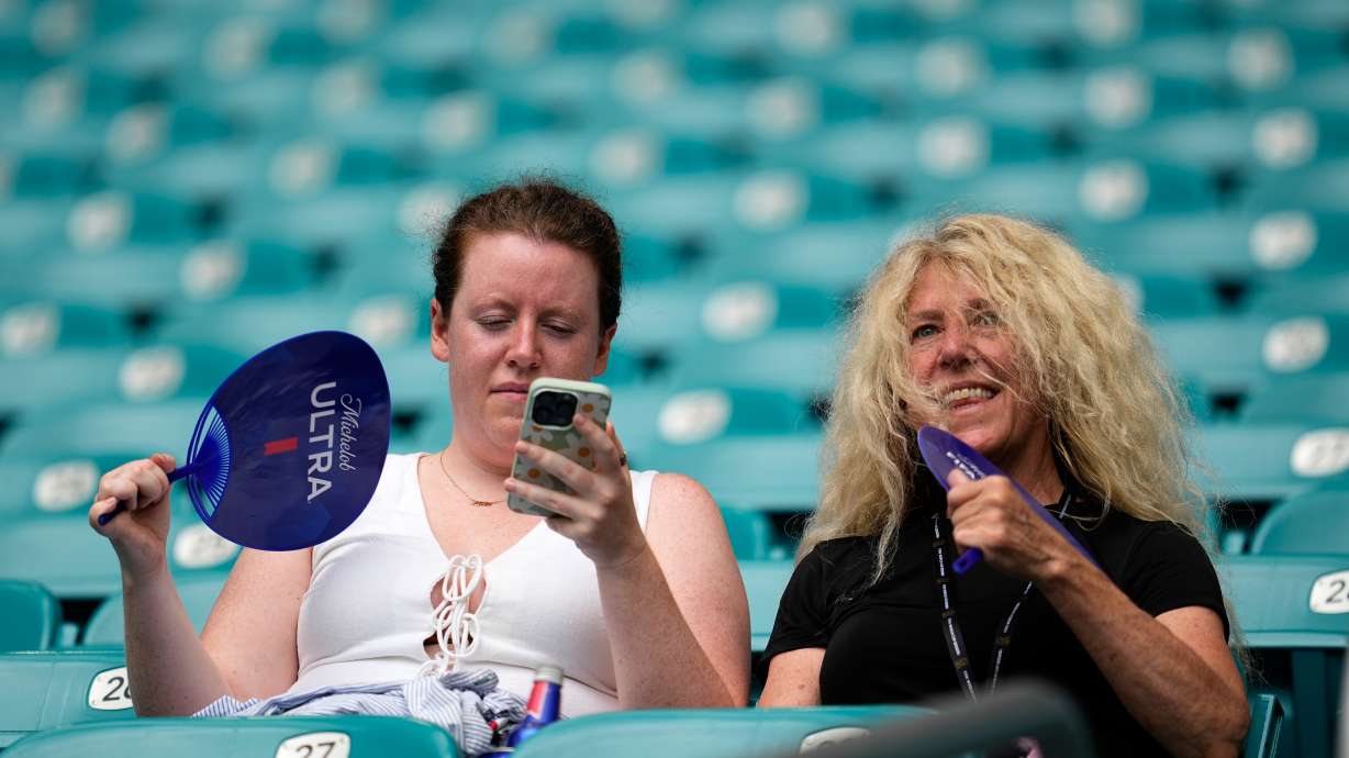 Spectators fan themselves before the World Cup quarterfinal soccer match between Norway and England in Miami Gardens, Fla., Saturday, July 11, 2026.