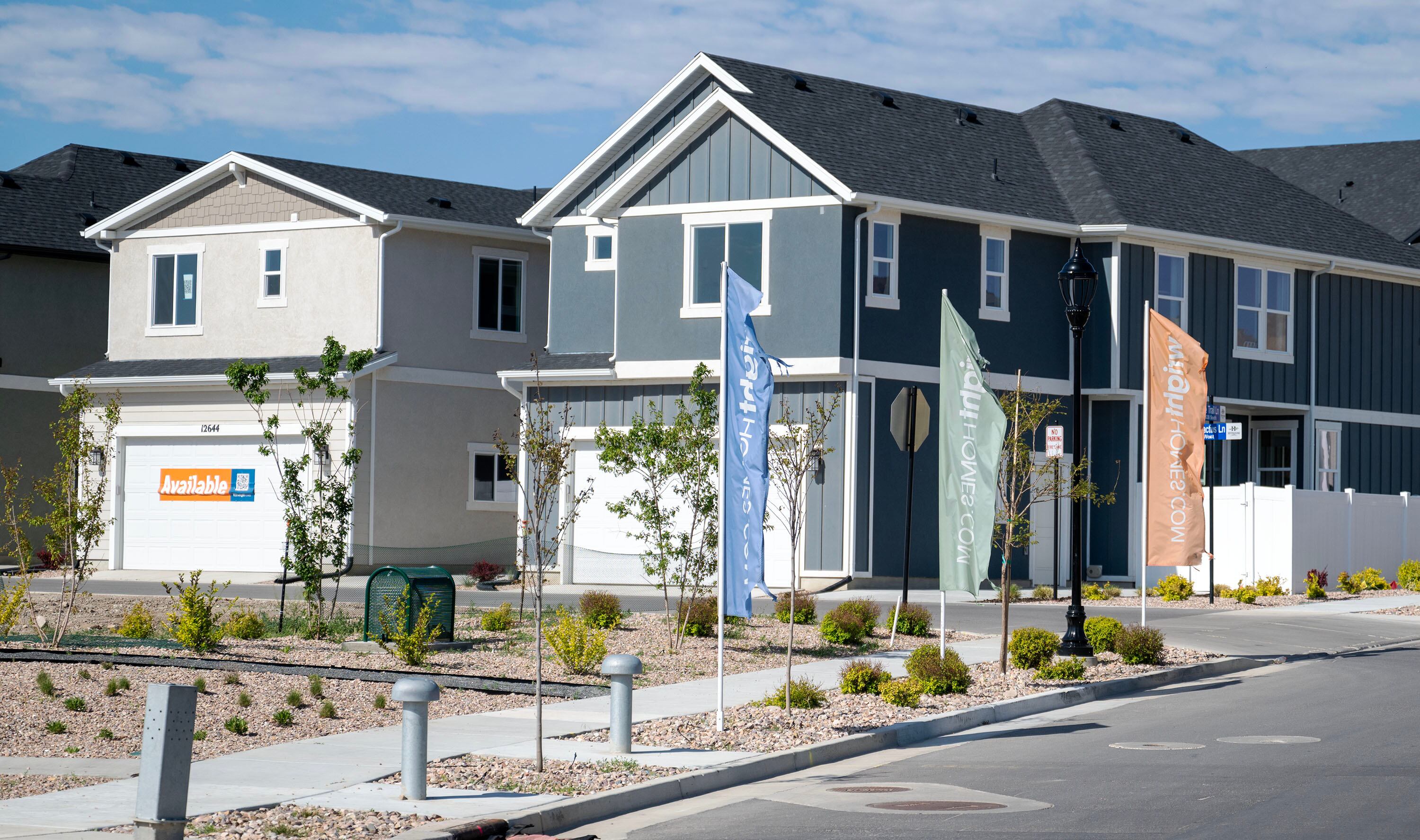 "Available" signs are seen in front of a model home in Herriman on May 12.