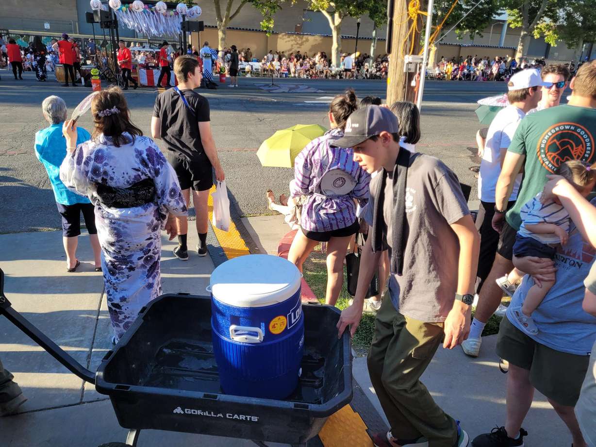 A team of Boy Scouts brings a five-gallon cooler of water through the crowds at the Japanese Obon Festival on Saturday, July 11, 2026.