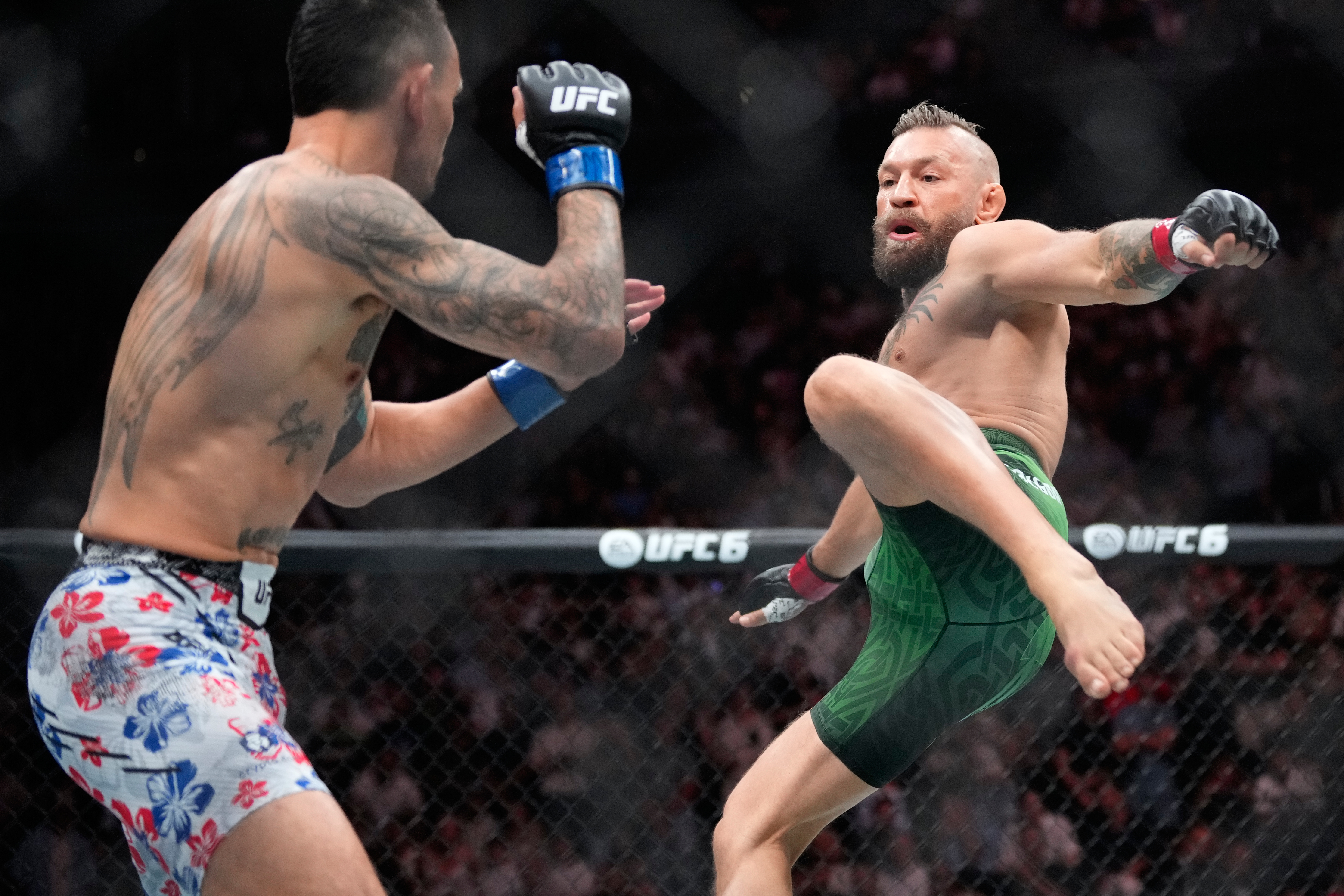 Conor McGregor, right, jumps into the air for a kick as he fights Max Holloway in a welterweight fight at the UFC 329 mixed martial arts event Saturday, July 11, 2026, in Las Vegas. 