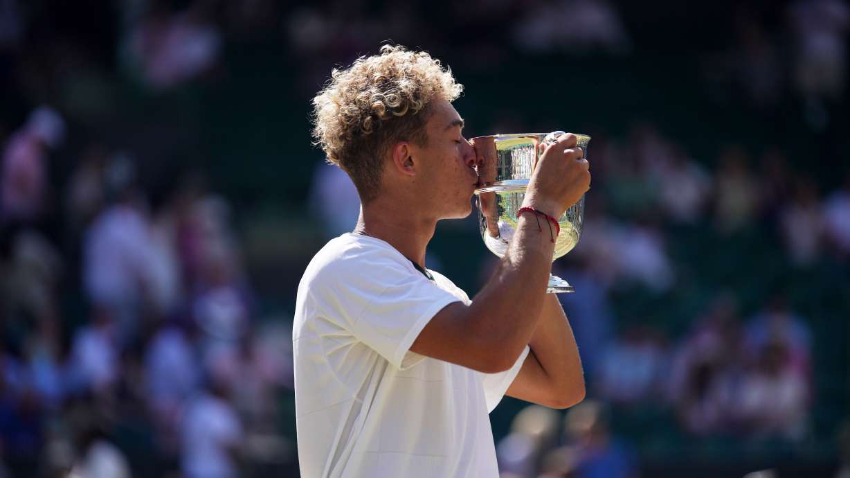 Jordan Lee of the United States kisses the trophy after winning against Cruz Hewitt of Australia in the boy's singles final at the Wimbledon Tennis Championships in London, Sunday, July 12, 2026.