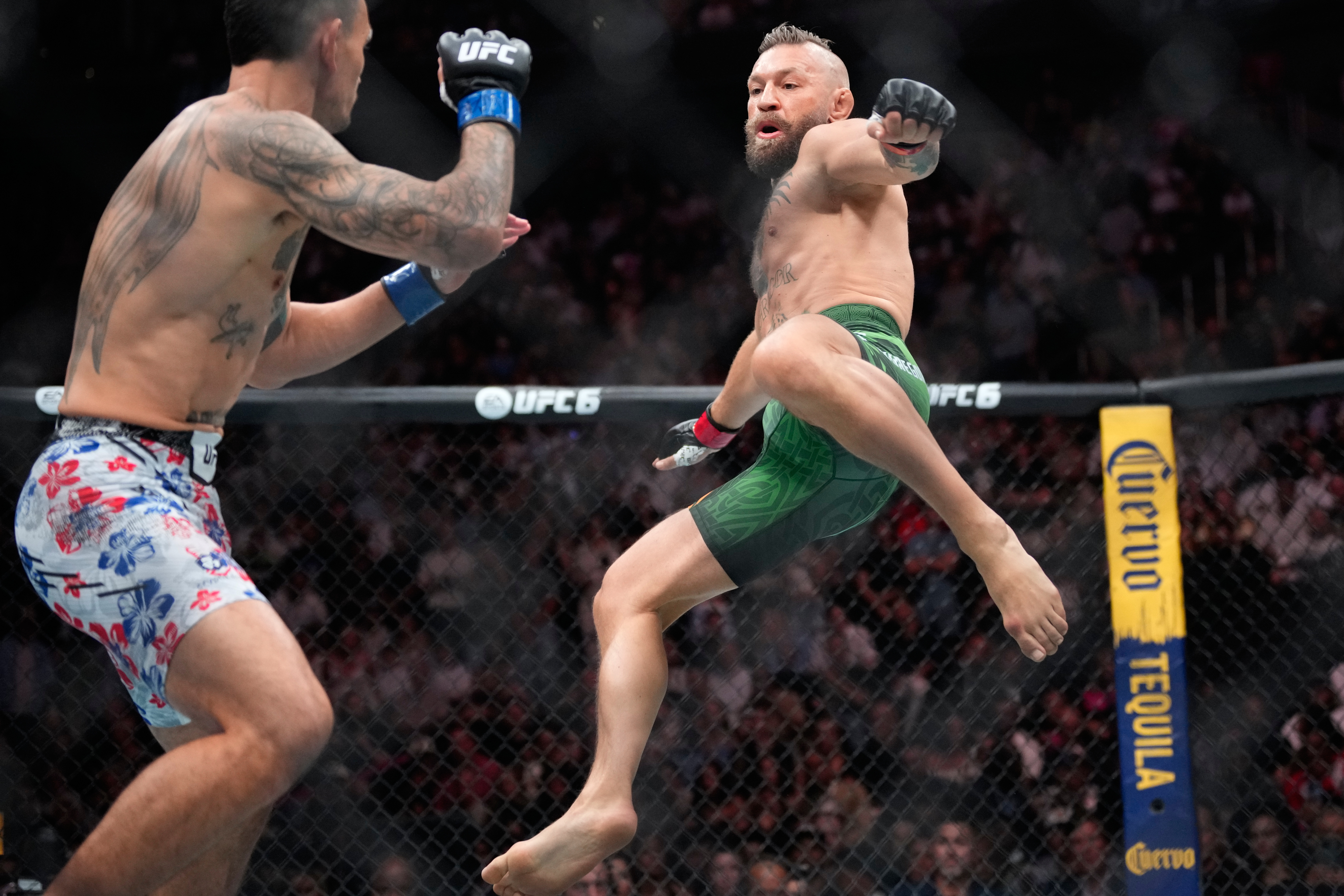 Conor McGregor, right, jumps into the air for a kick as he fights Max Holloway in a welterweight fight at the UFC 329 mixed martial arts event Saturday, July 11, 2026, in Las Vegas. 