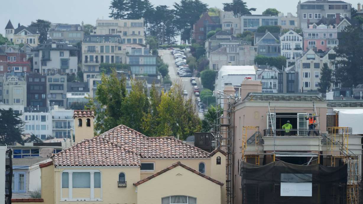 A construction crew works as homes and properties are shown in San Francisco, Oct. 10. Home prices nationwide are setting new records, but some areas, like San Francisco, are more expensive than others.