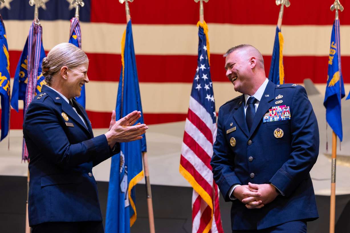 Col. Eric B. Quidley smiles as Lt. Gen. Jennifer Hammerstedt applauds him for his new position during a change of command ceremony at the Hill Aerospace Museum on Monday.