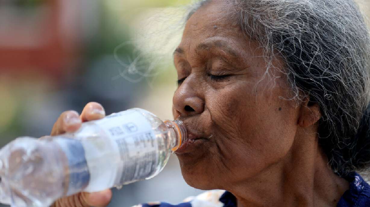 Lata Blake drinks water at the Artesian Well Park during a heat wave in Salt Lake City on Monday. Salt Lake City reached an all-time heat record on Sunday, hitting a historic 109 degrees.