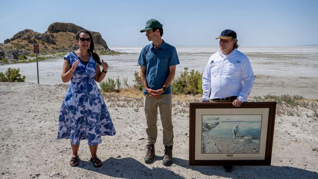 Rhonda Lauritzen, Ben Abbott and Val Anderson are pictured Monday near Lone Rock in the dry bed of the Great Salt Lake. Lake water used to surround the rock, a stopping point on a tour of the area on Monday led by opponents of the proposed Box Elder County data center proposal.