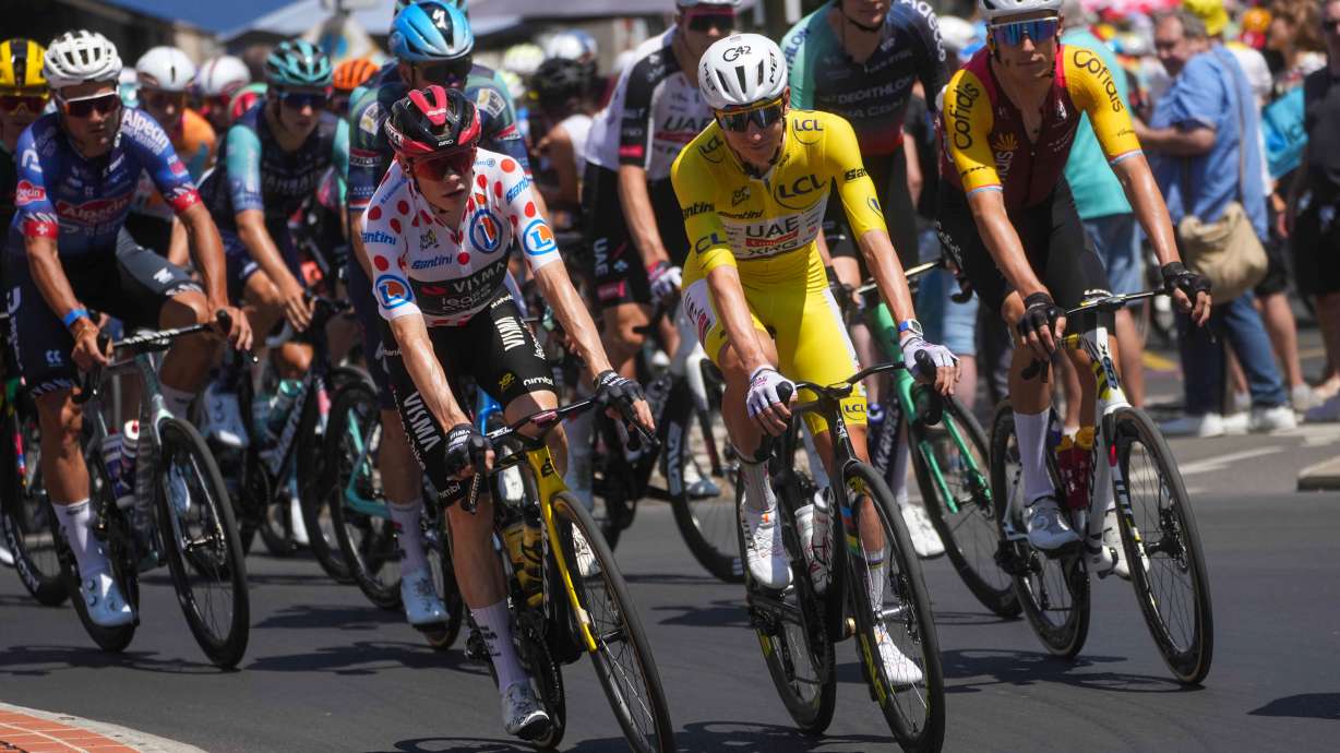 Slovenia's Tadej Pogacar, center, wearing the overall leader's yellow jersey, rides in the pack during the tenth stage of the Tour de France cycling race with start in Aurillac and finish in Le Lioran, during the Tour de France Cycling race in France, Tuesday, July 14, 2026.