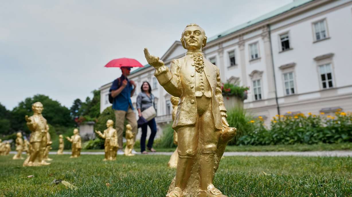 People pass 400 gold colored plastic Mozart sculptures by German artist Ottmar Hoerl from Nuremberg before the 270th birthday of composer Wolfgang Amadeus Mozart in Salzburg, Austria, Wednesday.