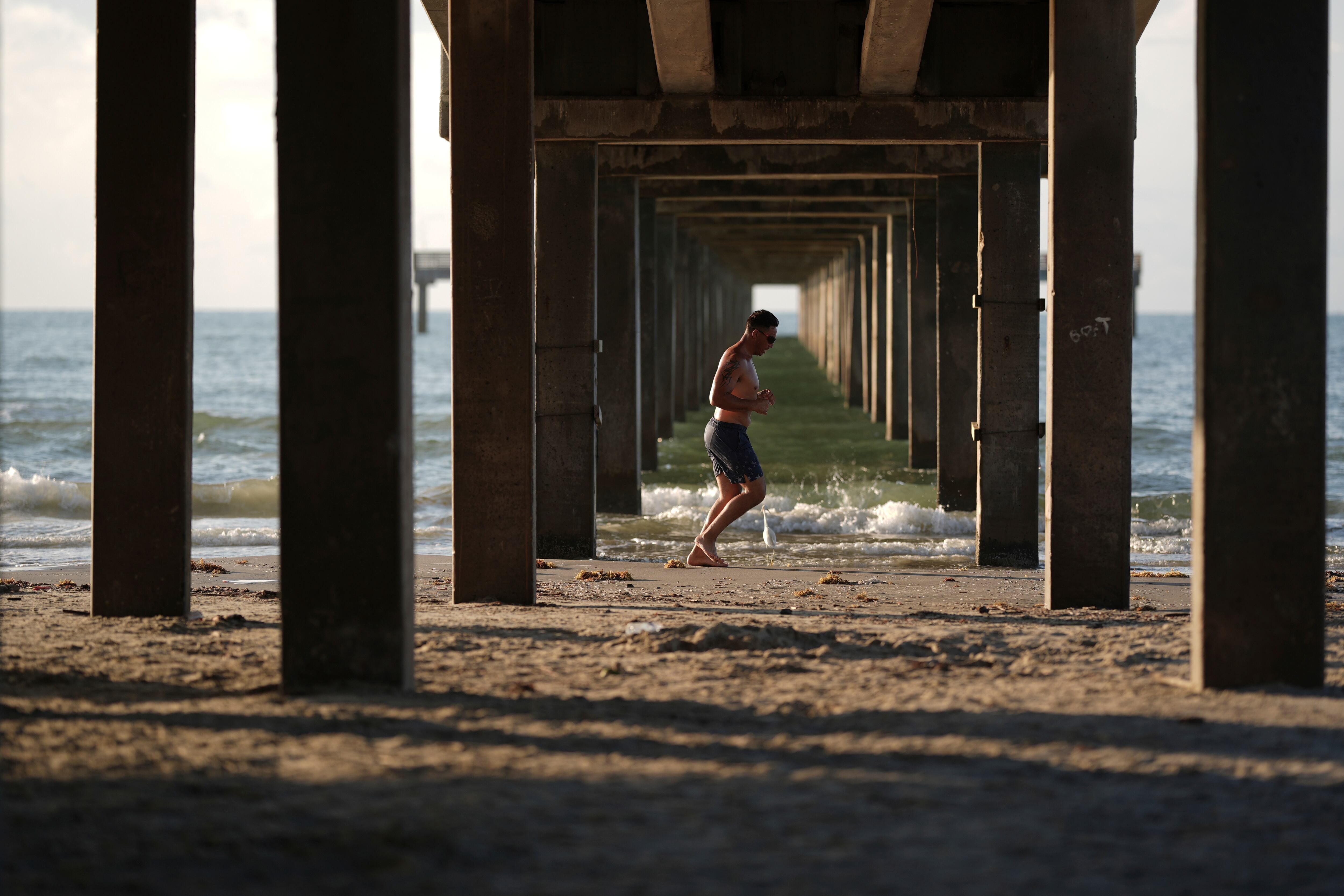 A man jogs along the beach in Port Aransas, Texas, Aug. 10, 2025.