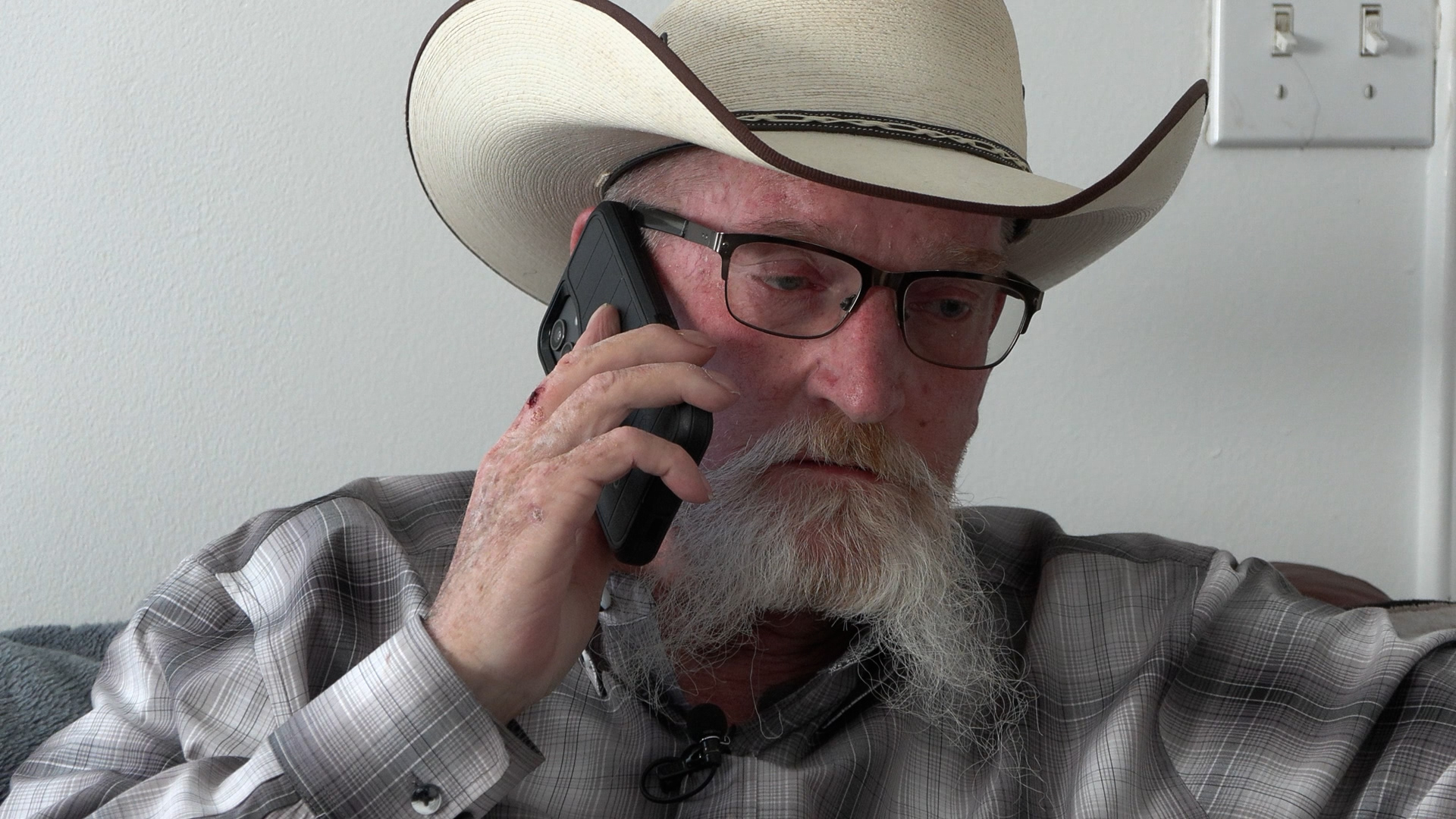 Curtis Sides talks on the phone in April after scammers posing as an internet provider gained access to his account and convinced him to ship expensive devices to them.