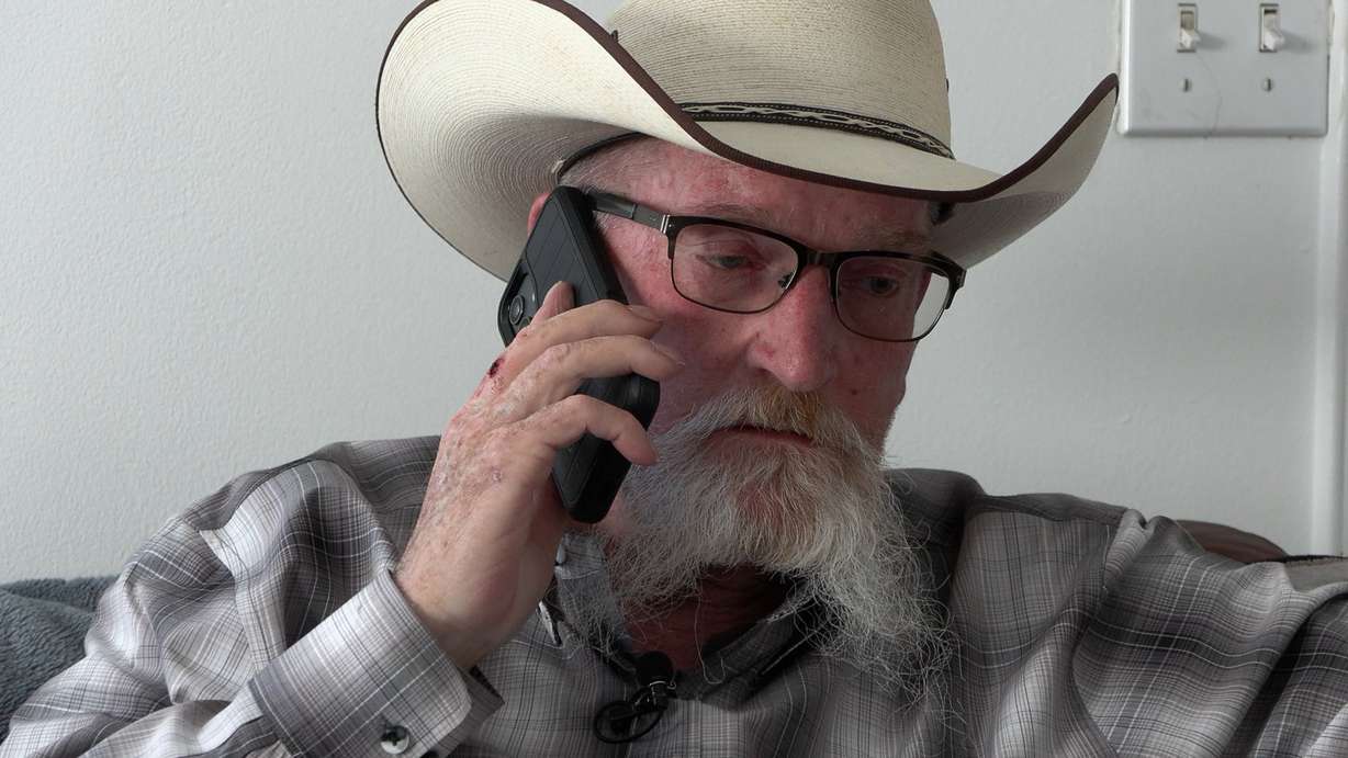 Curtis Sides talks on the phone in April after scammers posing as an internet provider gained access to his account and convinced him to ship expensive devices to them.