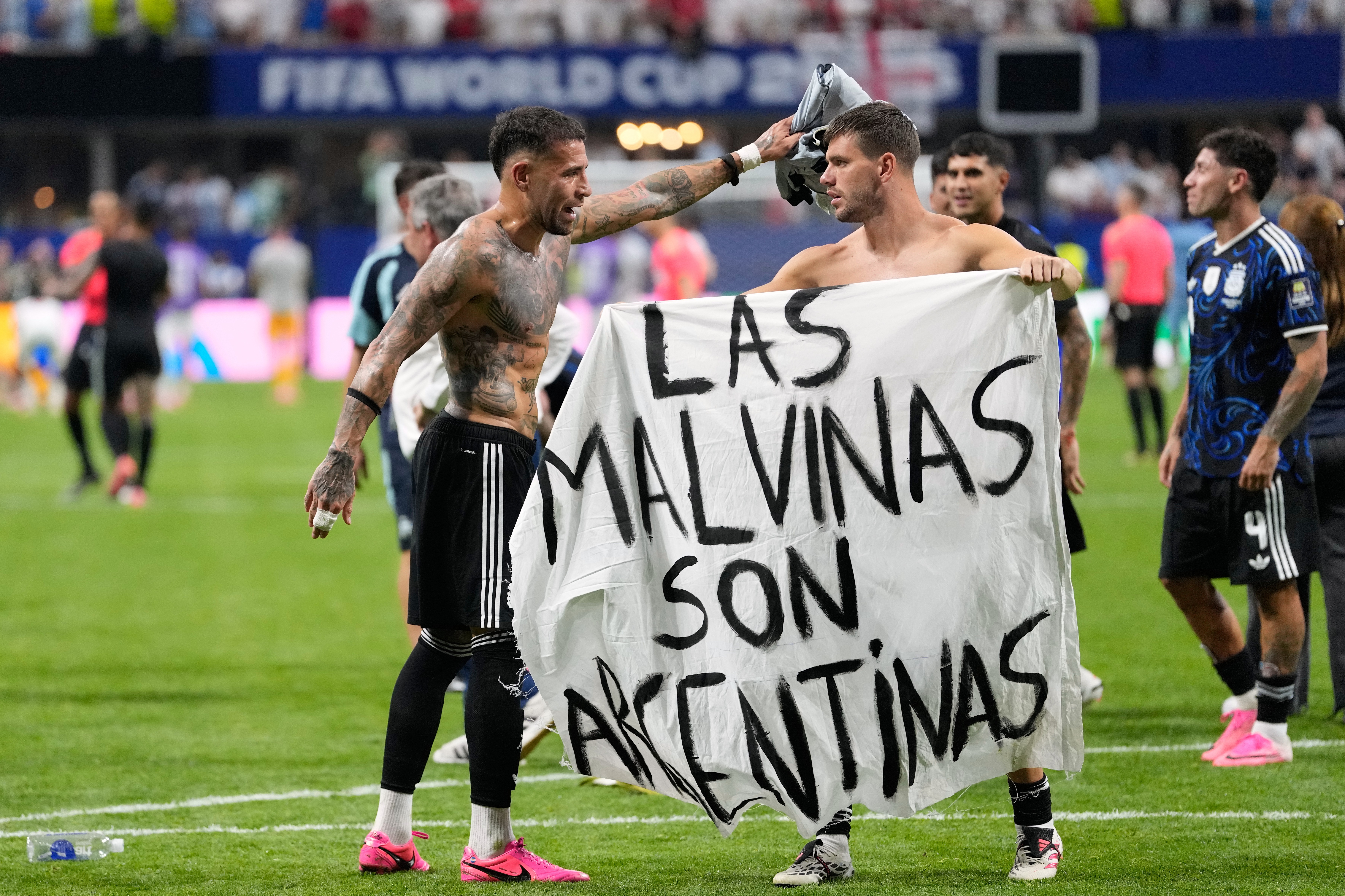 Argentina's Giovani Lo Celso holds a banner with the words "The Malvinas are Argentine", referring to the Falkland Islands, while teammate Argentina's Nicolas Otamendi gestures to him, at the end of the World Cup semifinal soccer match between England and Argentina in Atlanta, Wednesday, July 15, 2026. 