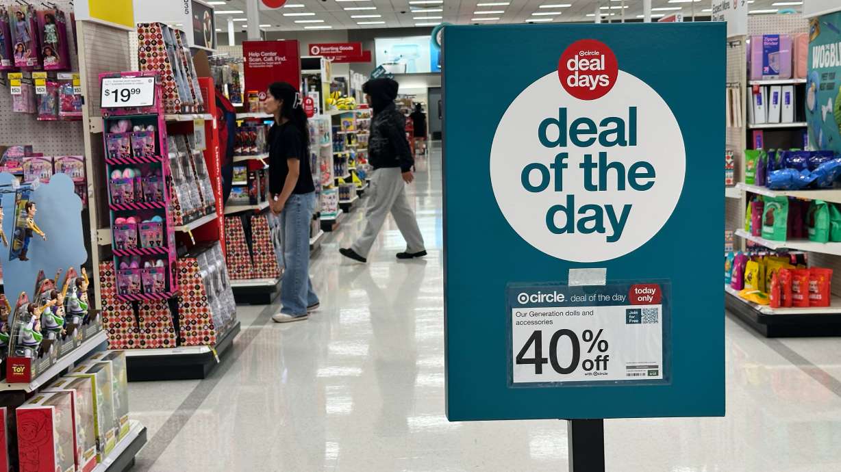 A sale information sign is displayed at a retail store in Wheeling, Ill., June 25. Shoppers slowed their spending in June from May amid continuing economic uncertainty and fading benefits from generous government tax refunds.