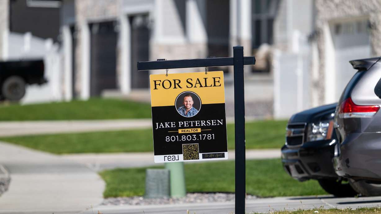A for-sale sign stands in front of a home in West Jordan on May 12. The cost of borrowing money to buy a home is continuing to climb as fighting intensifies in the war launched earlier this year by the U.S. and Israel in Iran.