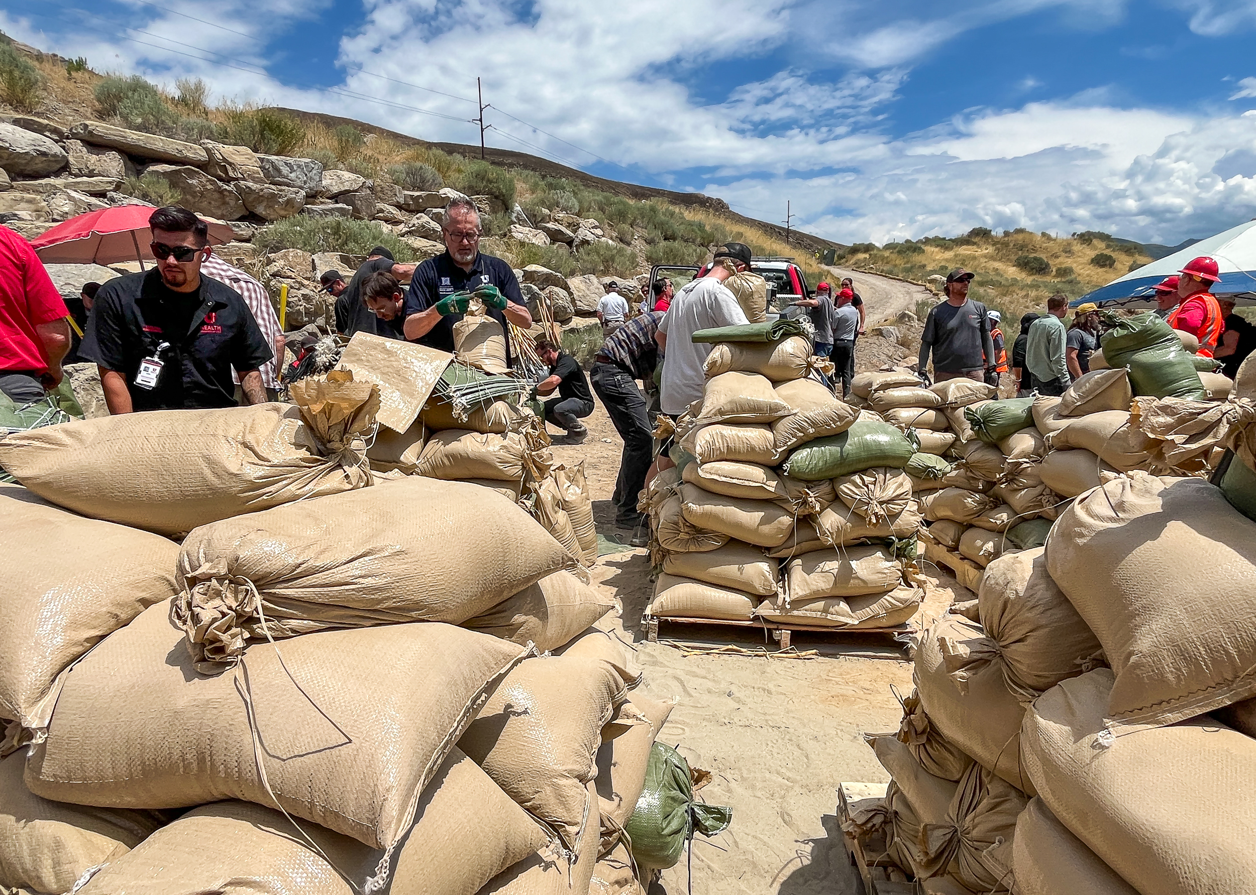 Volunteers fill sandbags near the Bonneville Fire burn scar in Salt Lake City on Thursday. Over 100 volunteers filled 2,000 sandbags that are being placed near the burn scar to help reduce flood impacts to mostly University of Utah Health buildings near where the fire burned last month.