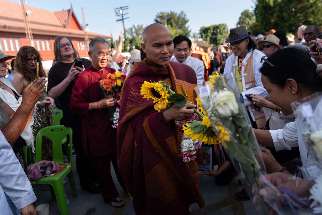 Bhikkhu Pannakara, a Buddhist monk who led a Walk for Peace from Fort Worth, Texas, to Washington, D.C., receives flowers from well-wishers during an event at Wat Thai of Los Angeles in North Hollywood, Calif., Monday. Pannakara has been in the spotlight since the walk earlier this year.