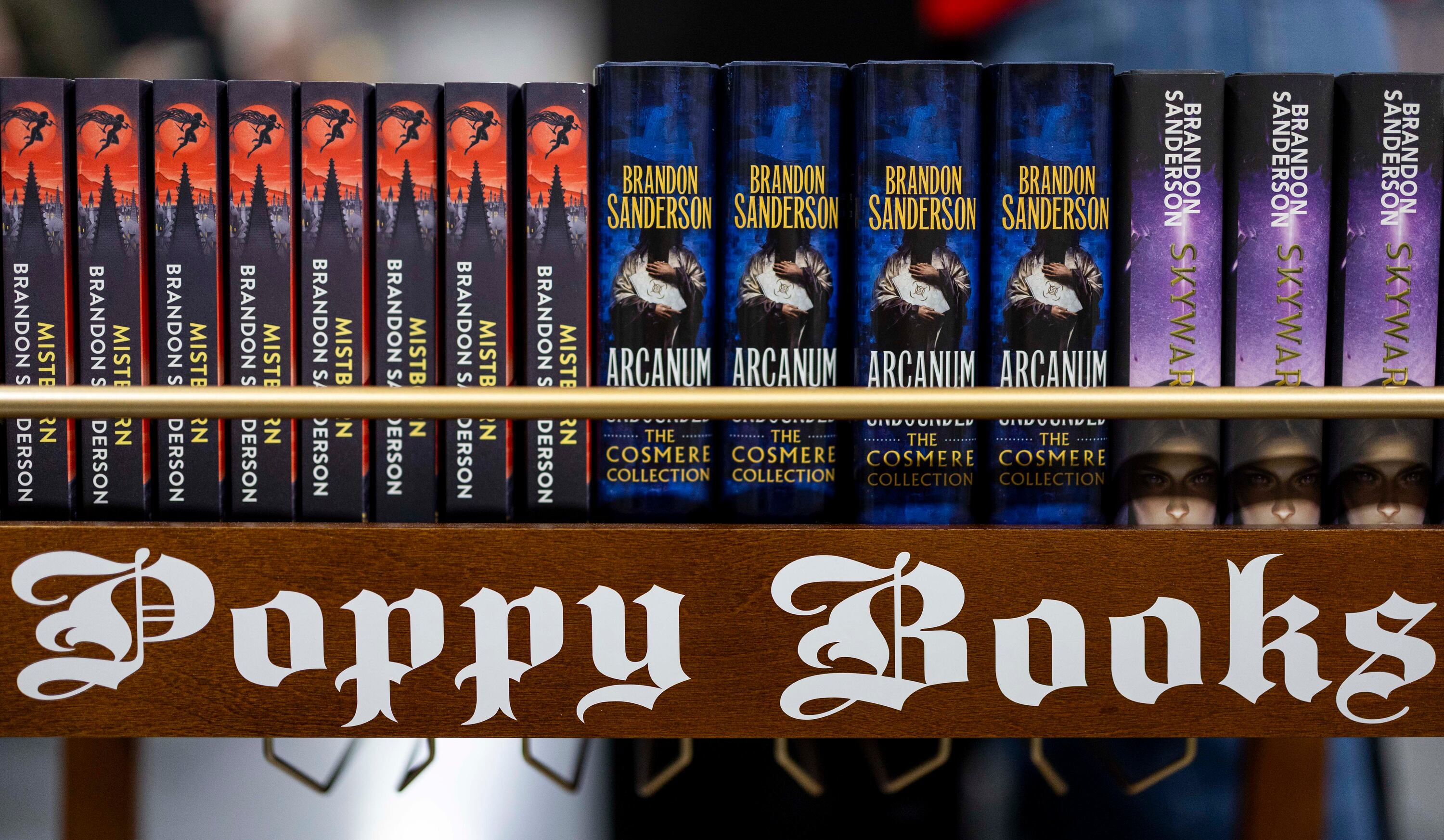 A Poppy Books stand displays some of Brandon Sanderson’s books before a signing session during Dragonsteel Nexus at the Salt Palace Convention Center in Salt Lake City on Dec. 4. Sanderson's "Mistborn" series, on the left side of the stand, celebrated its 20th anniversary on Friday.