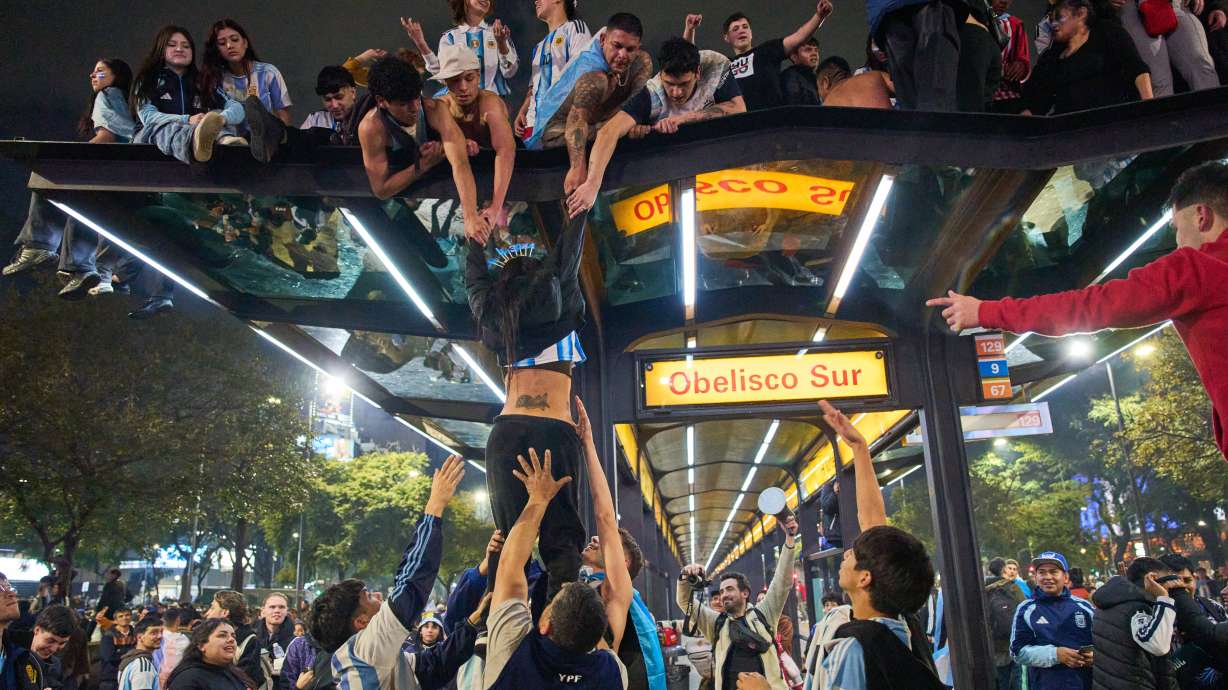 Fans climb on to a bus stop during celebrations of Argentina's victory over England in a World Cup semifinal soccer match in downtown Buenos Aires, Argentina, Wednesday, July 15, 2026.