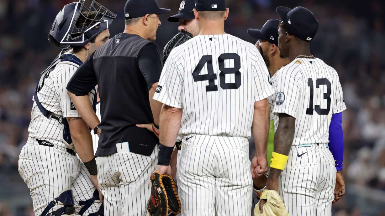 New York Yankees manager Aaron Boone, second left, confers with Gerrit Cole during the seventh inning of a baseball game against the Los Angeles Dodgers, Friday, July 17, 2026, in New York.