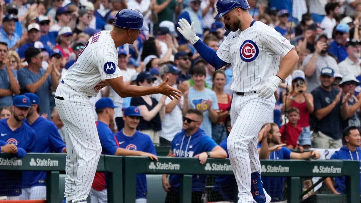 Chicago Cubs' Michael Busch, right, celebrates with third base coach Quintin Berry after hitting a solo home run during the first inning of a baseball game against the Minnesota Twins in Chicago, Saturday, July 18, 2026.