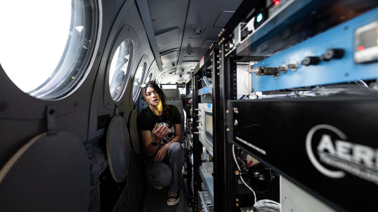 Anna Robertson, a research scientist with the University of Wyoming, shows off scientific instruments during a tour of the school's King Air airborne research aircraft on Friday. The aircraft will be flying over the Salt Lake Valley over the next six weeks, hunting for summer ozone.