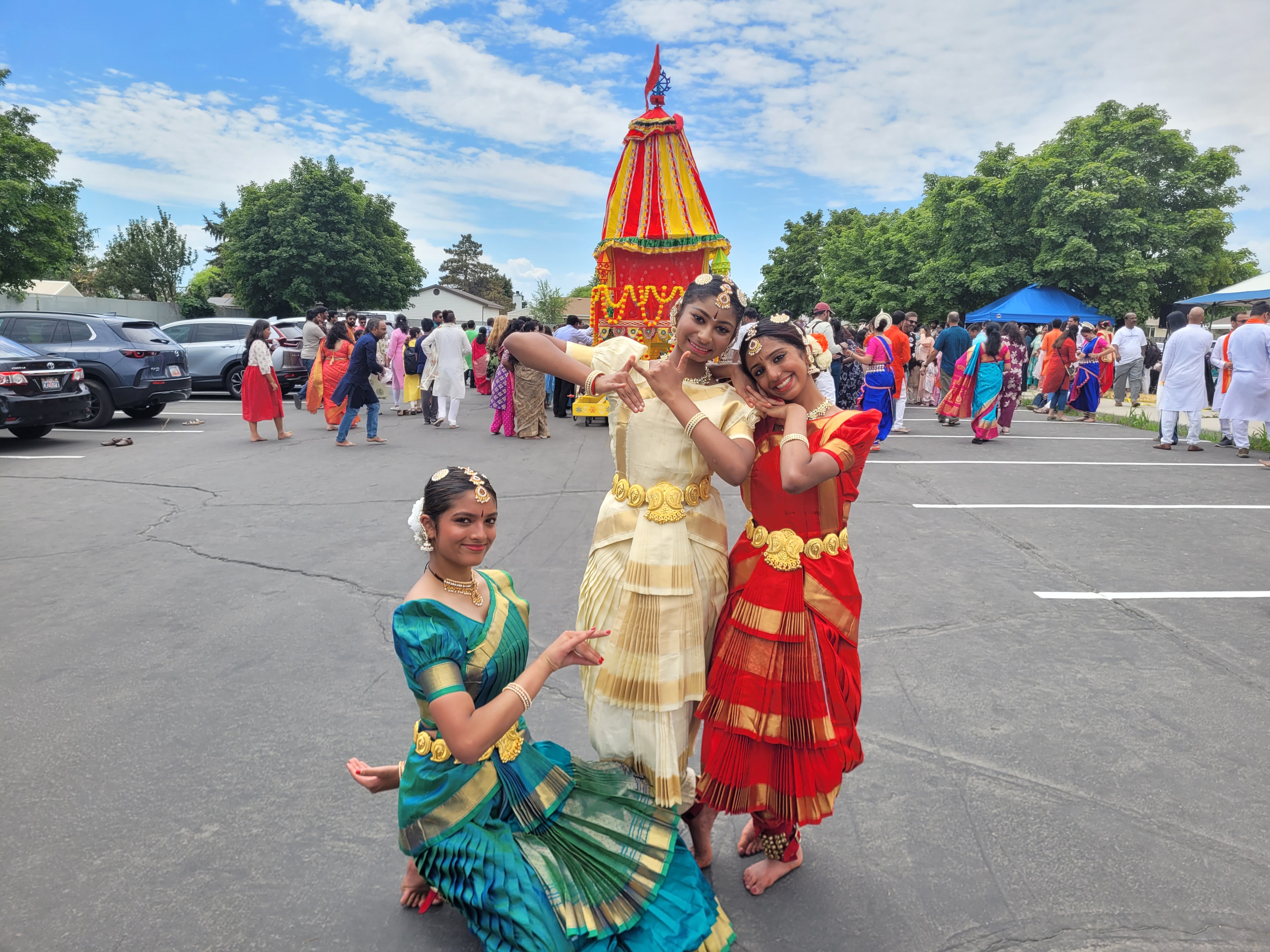 From left to right, Saloni Shah, Iyra Maringanti and Poorvi Nandiraju pose behind the Ratha containing Hindu gods in Kearns on Saturday, July 18, 2026.
