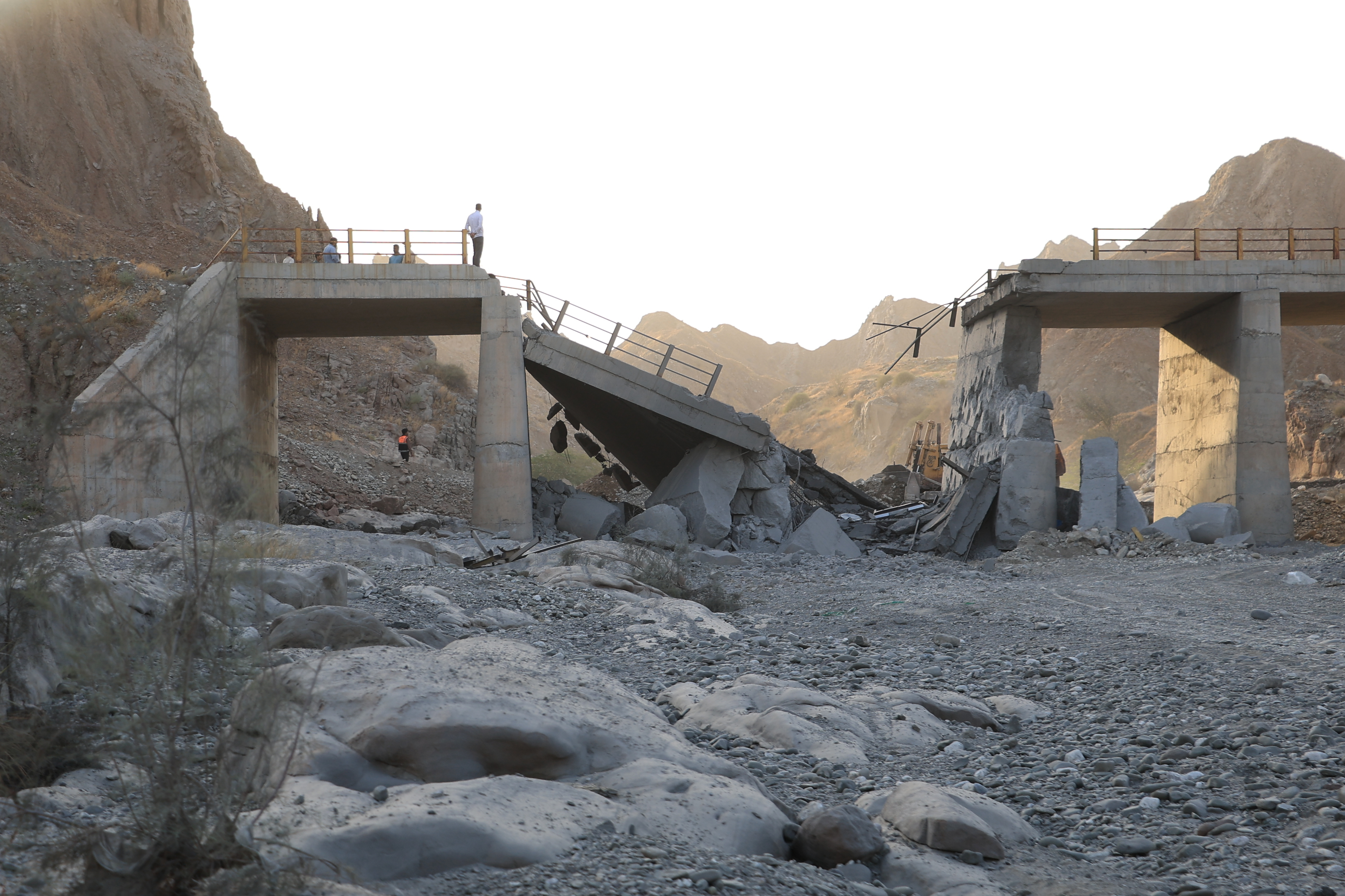 People stand on a bridge destroyed after a strike in Hormozgan province, southern Iran, Saturday.