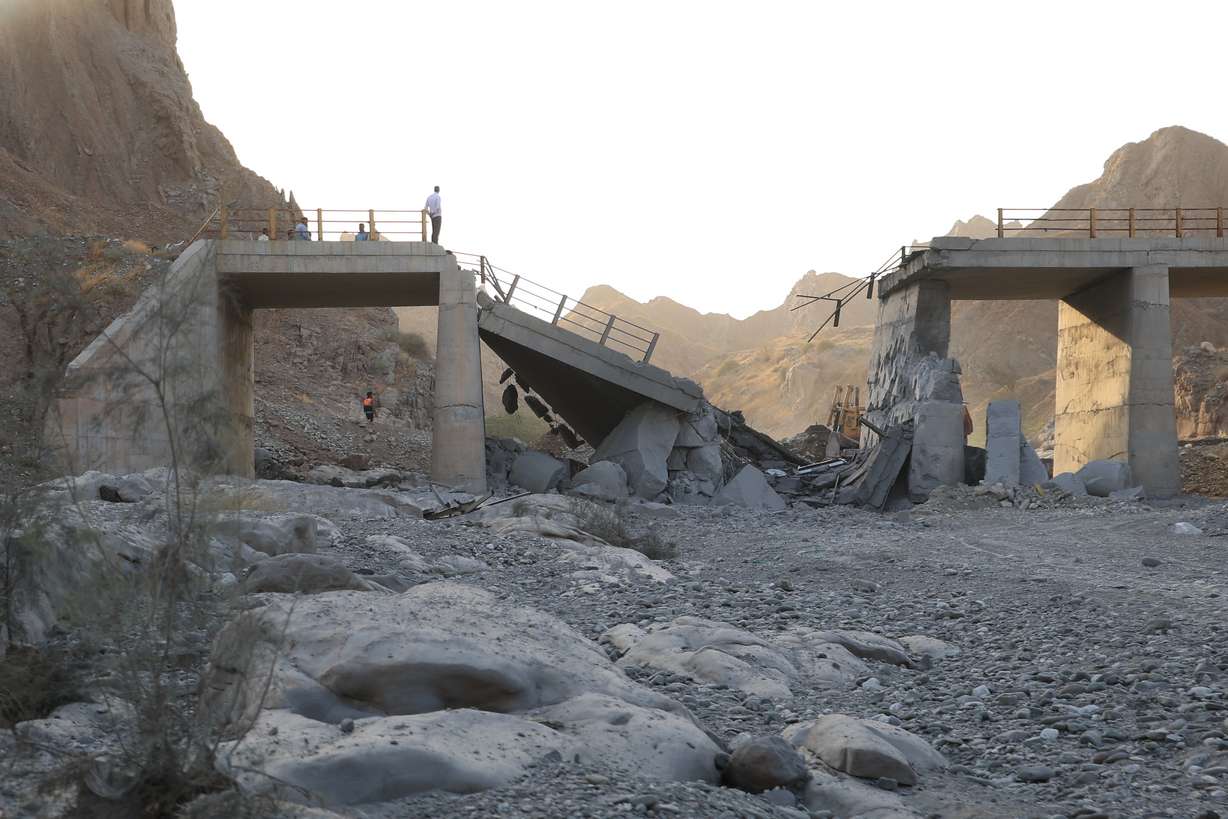 People stand on a bridge destroyed after a strike in Hormozgan province, southern Iran, Saturday.