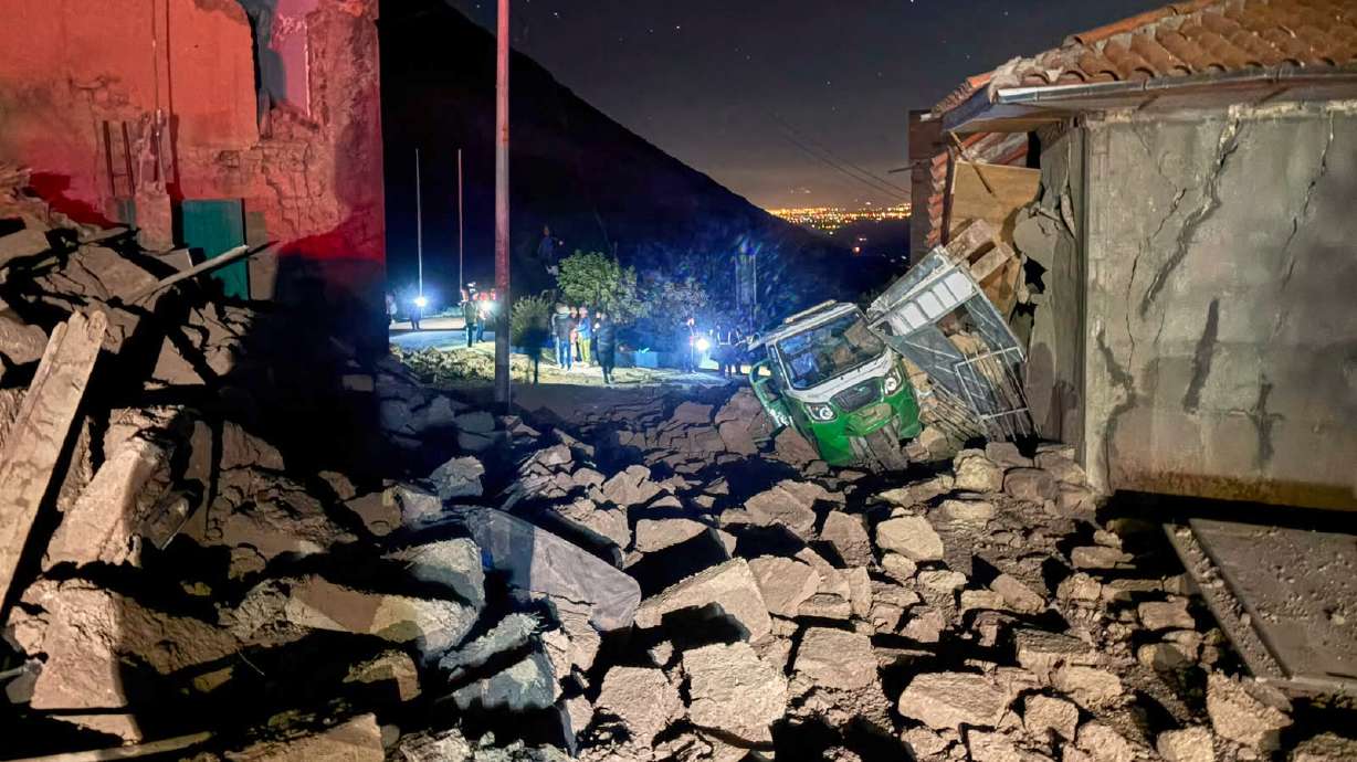 A motor tricycle is stuck amid the debris of homes that collapsed after an earthquake struck Pumpuya, Peru, Sunday.