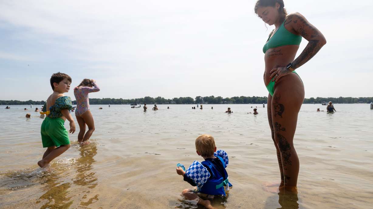 Lexis Aubile watches her son, Atticus, play in the water as they try to beat the heat at Ramona Park in Portage, Mich., on Tuesday.