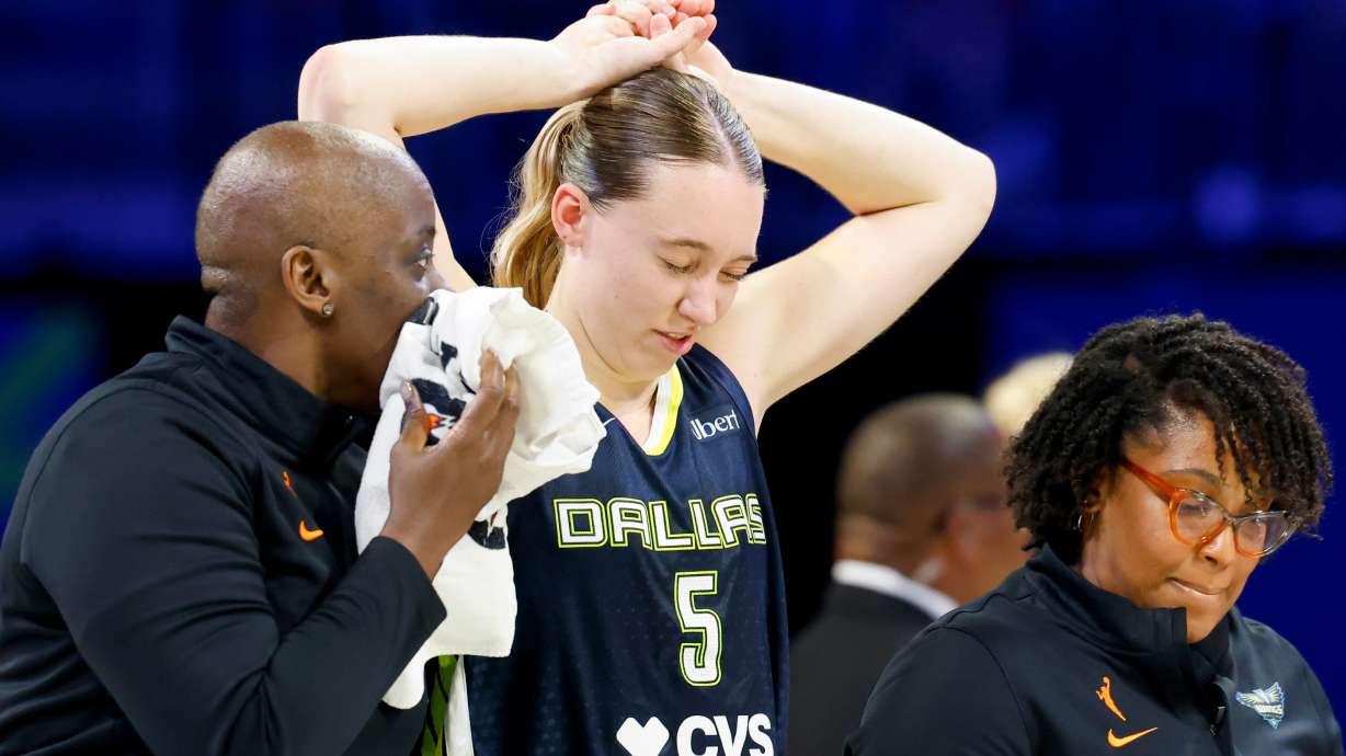 Dallas Wings guard Paige Bueckers (5) holds her head after a collision with Los Angeles Sparks forward Nneka Ogwumike during the second half of a WNBA basketball game, Sunday, July 19, 2026, in Arlington, Texas.