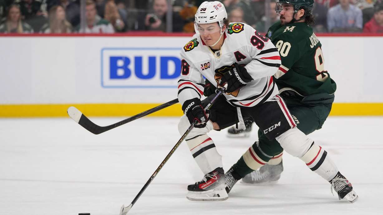 FILE - Chicago Blackhawks center Connor Bedard (98) skates with the puck as Minnesota Wild left wing Marcus Johansson (90) defends during the second period of an NHL hockey game, March 19, 2026, in St. Paul, Minn.