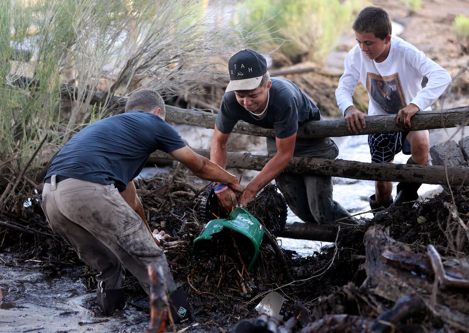 Dray Smith, Krosby Hollingshead and Lincoln Smith clear debris that washed downstream so flood waters can flow freely after flooding in Beaver on Monday.