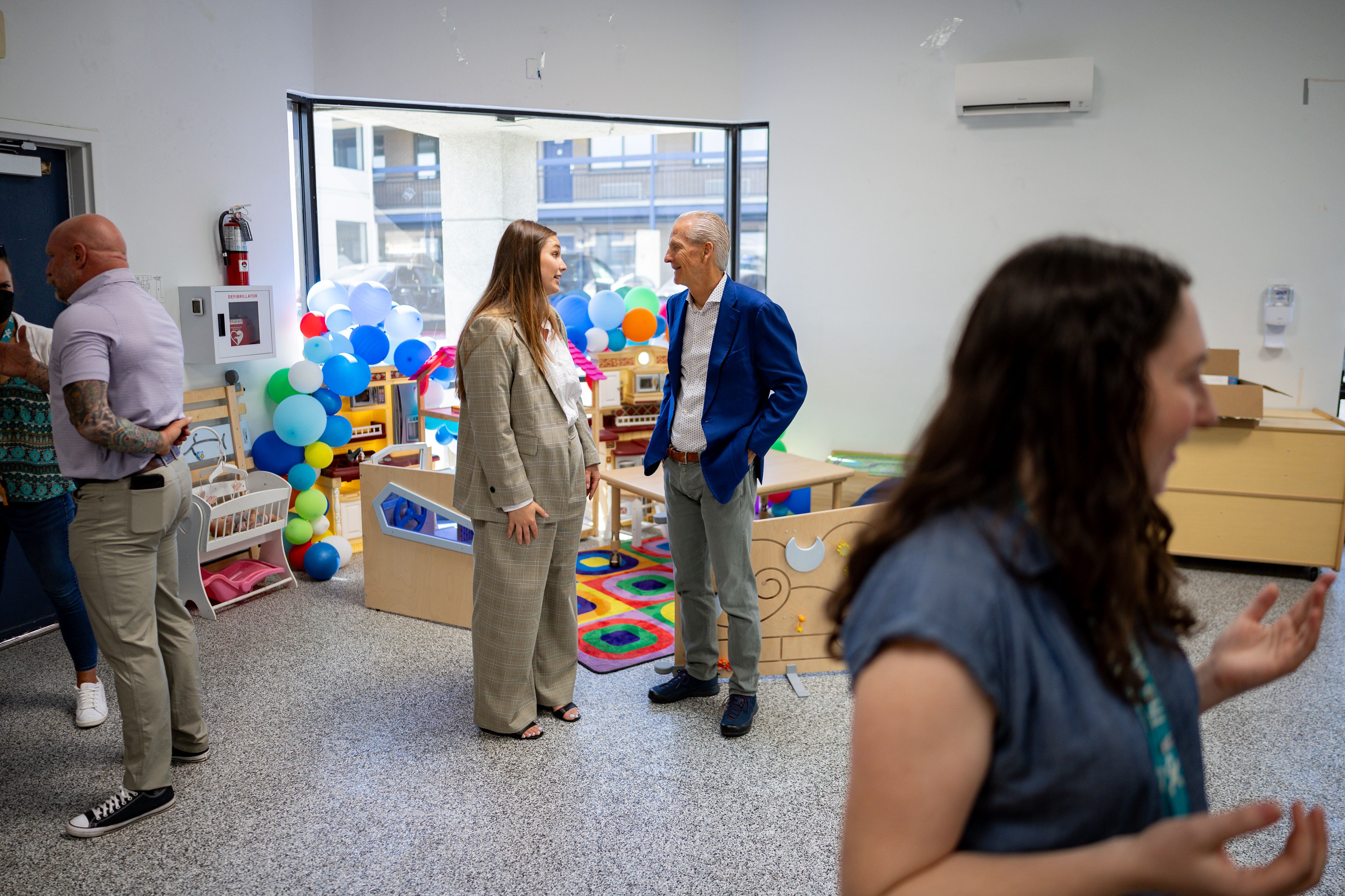 Lily Ward, Utah Office of Homeless Services program manager, center left, speaks with Wayne Niederhauser, board member for Shelter the Homeless and former Utah state Homeless Coordinator, center right, after first lady Abby Cox read to children and promoted early literacy at The FINCH (Family Interim Noncongregate Housing), operated by The Road Home, in South Salt Lake on Tuesday.