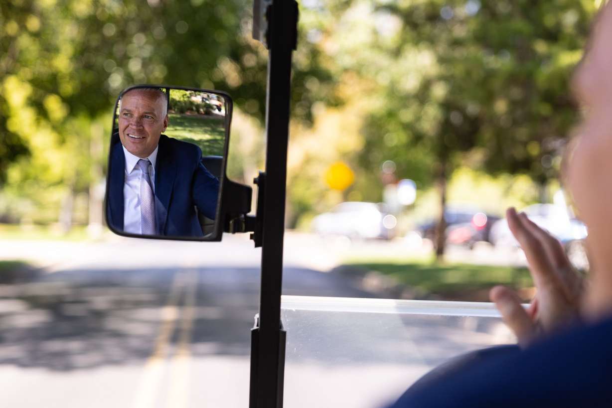 Brigham Young University President C. Shane Reese waves from a golf cart near the Former Presidents’ Home on campus in Provo on Monday. Reese has made it a point to foster connections in Mapleton by simply waving at others.