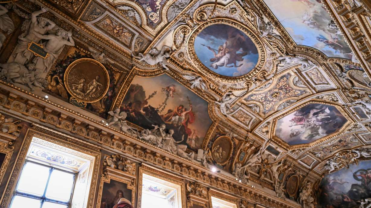 A visitor looks on during the reopening to the public of the Apollo Gallery, at the Louvre museum in Paris, Wednesday. The museum has removed the collections and precious jewels in the gallery.