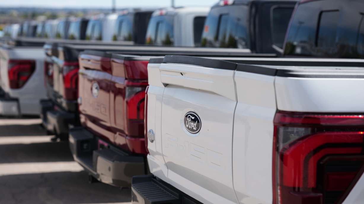 Unsold 2026 F-150 pickup trucks sit in a long line outside a Ford agency April 12, in Centennial, Colo. Automakers are now branching into the energy business as demand on the grid increases and sales of electric vehicles slow.