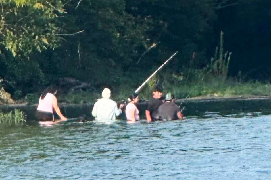 A group of people Pastor Marcus L. Martin believes were those who died in a recent drowning accident, are shown fishing along the Scioto River in Powell, Ohio, Sunday. It isn't clear if this was the group of adults that drowned in the river.