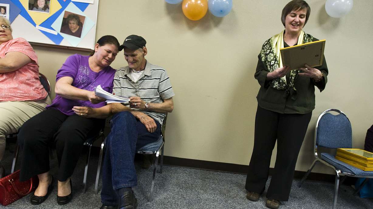 Graduates Monica Pike and Michael Sandlin of the Circles program laugh while Circles coach Joan Dixon announces other graduates in Provo on May 10, 2011. The program is being forced to scale back operations after losing federal grant funding.