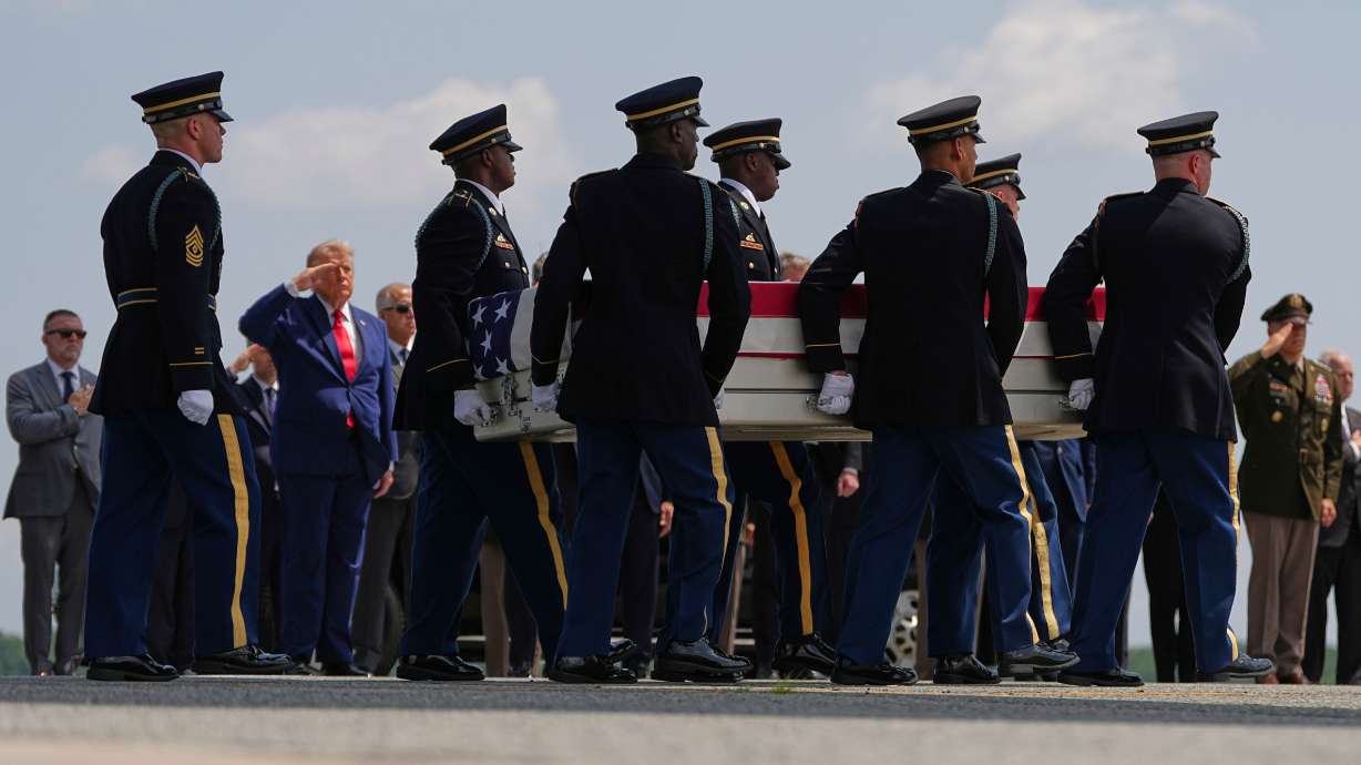 President Donald Trump salutes as a U.S. Army carry team moves a transfer case containing the remains of Pvt. Isabella Gonzales of Carrollton, Texas, on Wednesday at Dover Air Force Base, Del.