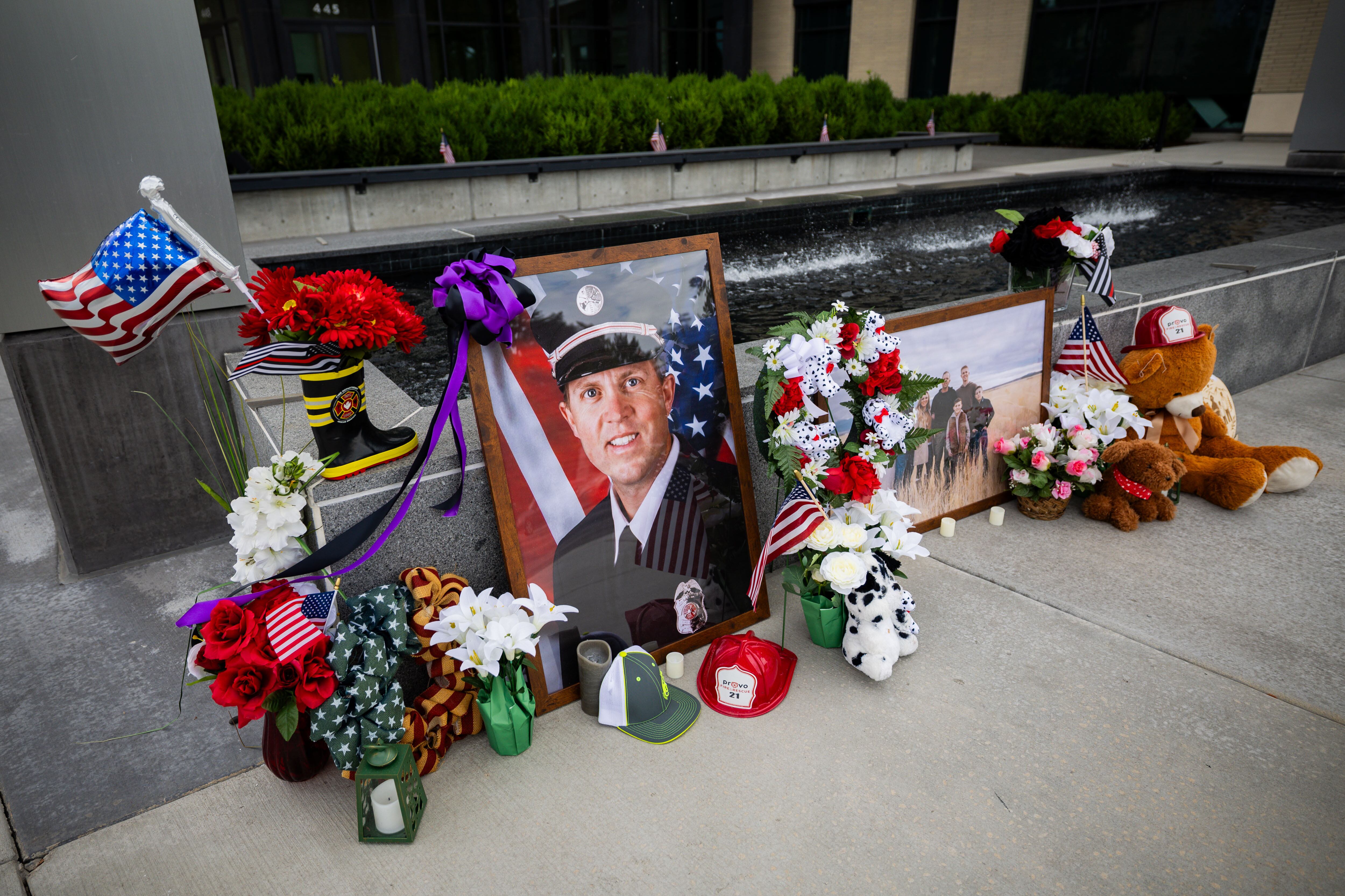 A memorial with flowers, stuffed animals and photos for Provo Fire Capt. Spencer Long and four members of his family who were killed in a flash flood during a weekend camping and hiking trip in Wayne County, outside of City Hall in Provo on Wednesday.