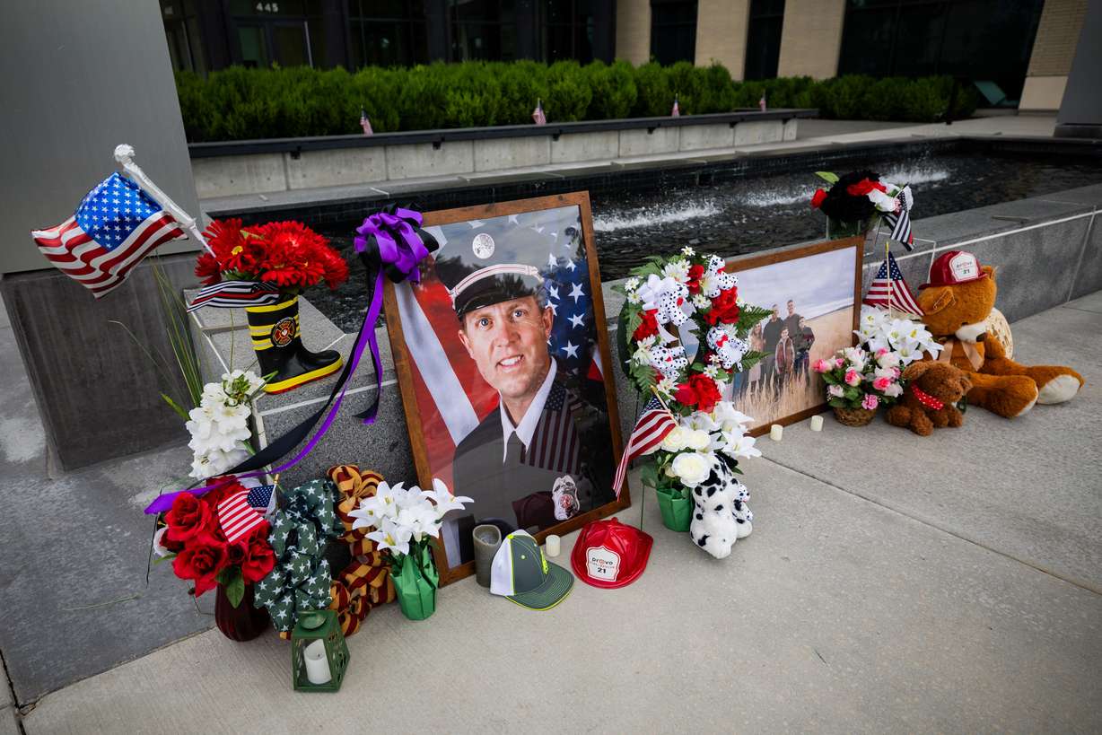 A memorial with flowers, stuffed animals and photos for Provo Fire Capt. Spencer Long and four members of his family who were killed in a flash flood during a weekend camping and hiking trip in Wayne County, outside of City Hall in Provo on Wednesday.