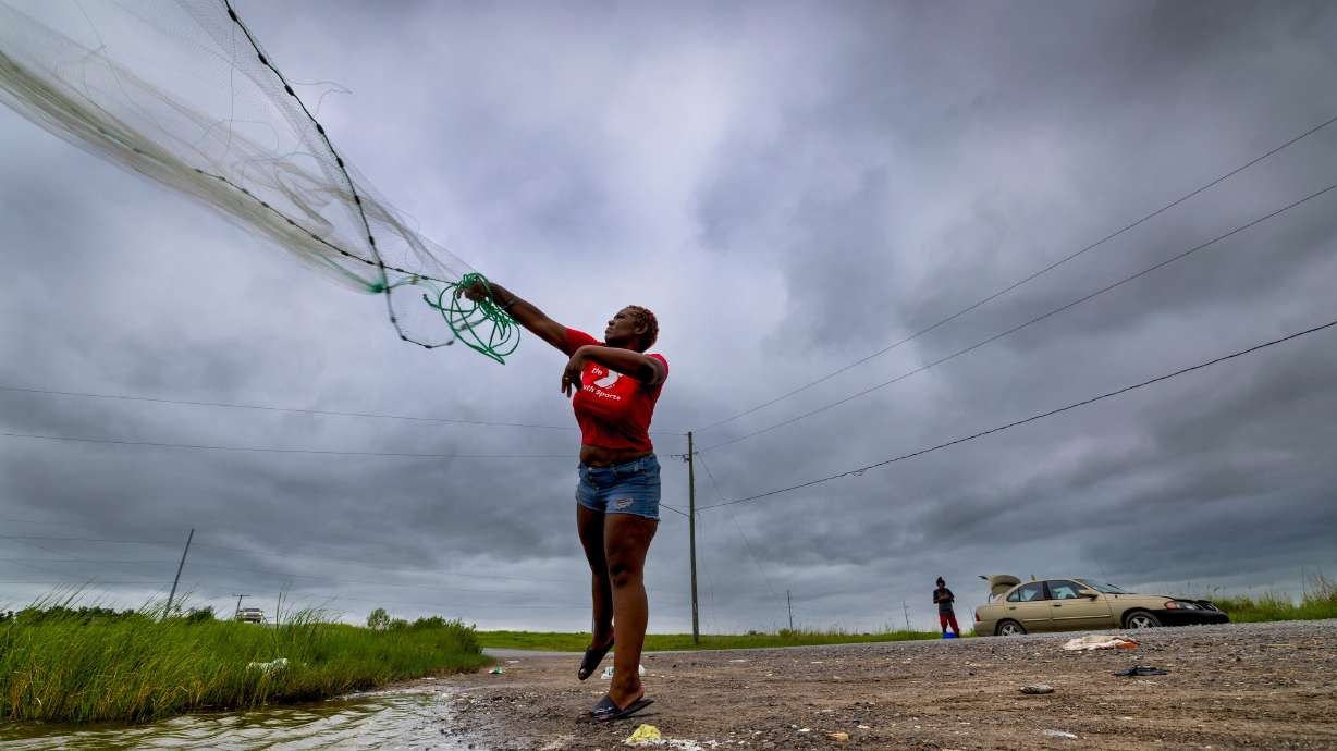 With skies darkening ahead of Tropical Storm Bertha, Latia Ancar practices her casting while she and a friend wait for the storm-driven tidal surge about 50 miles south of New Orleans on Wednesday, hoping it will bring more fish. The storm made a second landfall near the Texas-Louisiana line on Thursday.