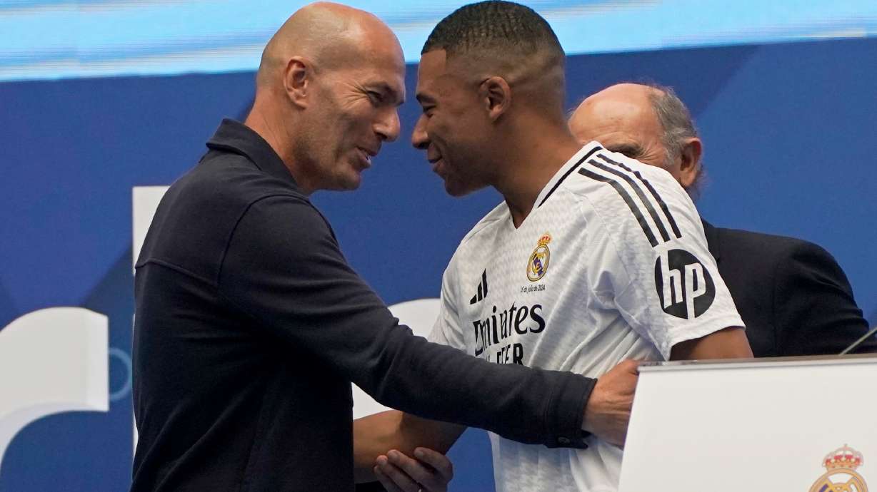 FILE - Former French player Zinedine Zidane, left, embraces Kylian Mbappe of France, as he is being presented to fans as a new Real Madrid player in Madrid, July 16, 2024.