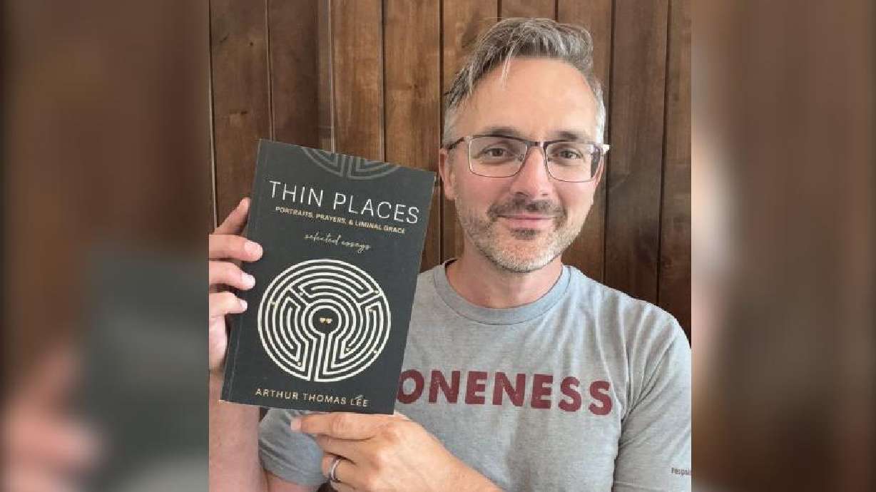 Rexburg author Arthur Lee holds up a copy of his latest book, "Thin Places: Portraits, Prayers, and Liminal Grace," traditionally published and now available online and in bookstores, Thursday.