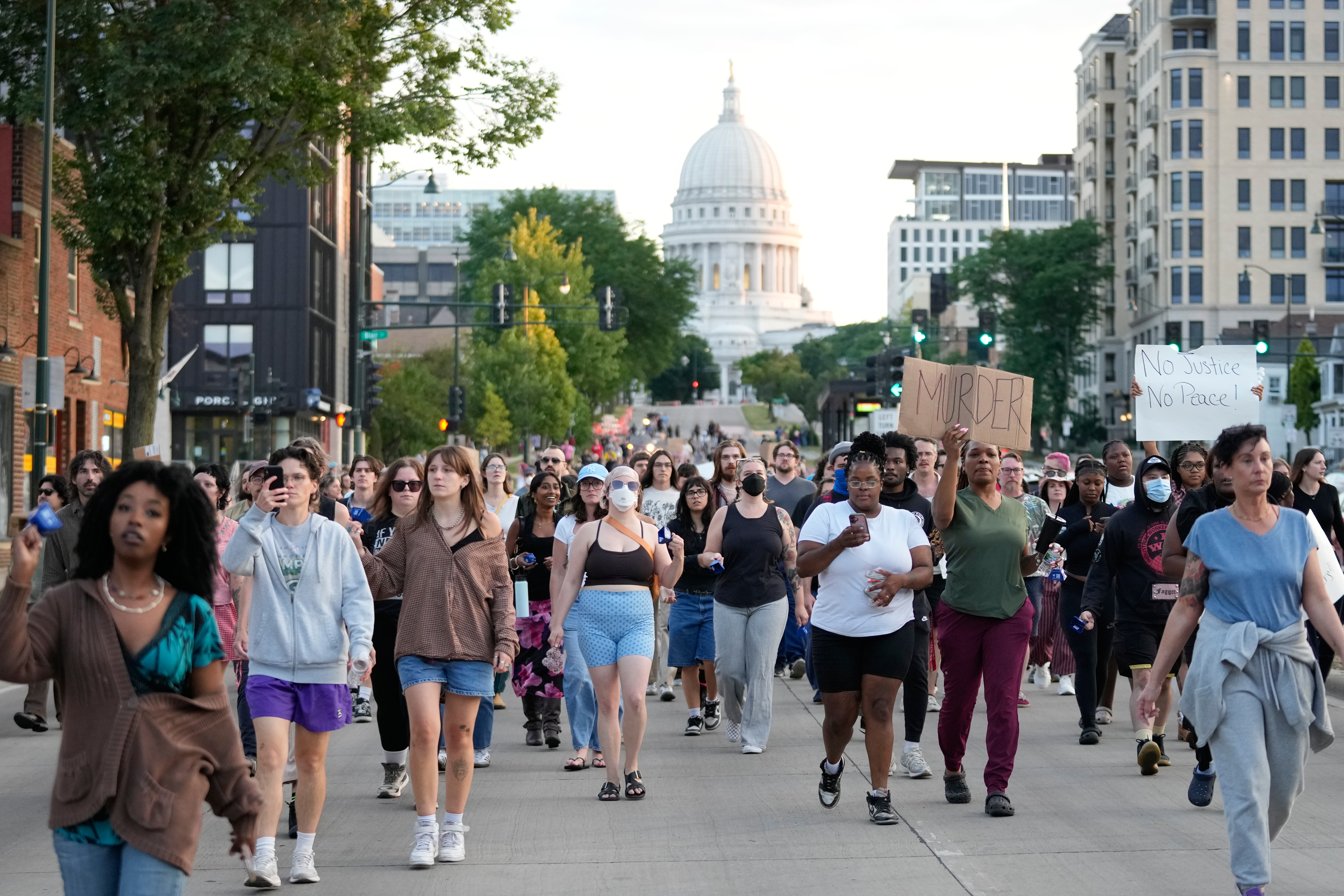 Protesters march after a Madison police officer shot and killed a man Wednesday, in Madison, Wis. Police are calling for calm, even as they've released few details about the shooting.