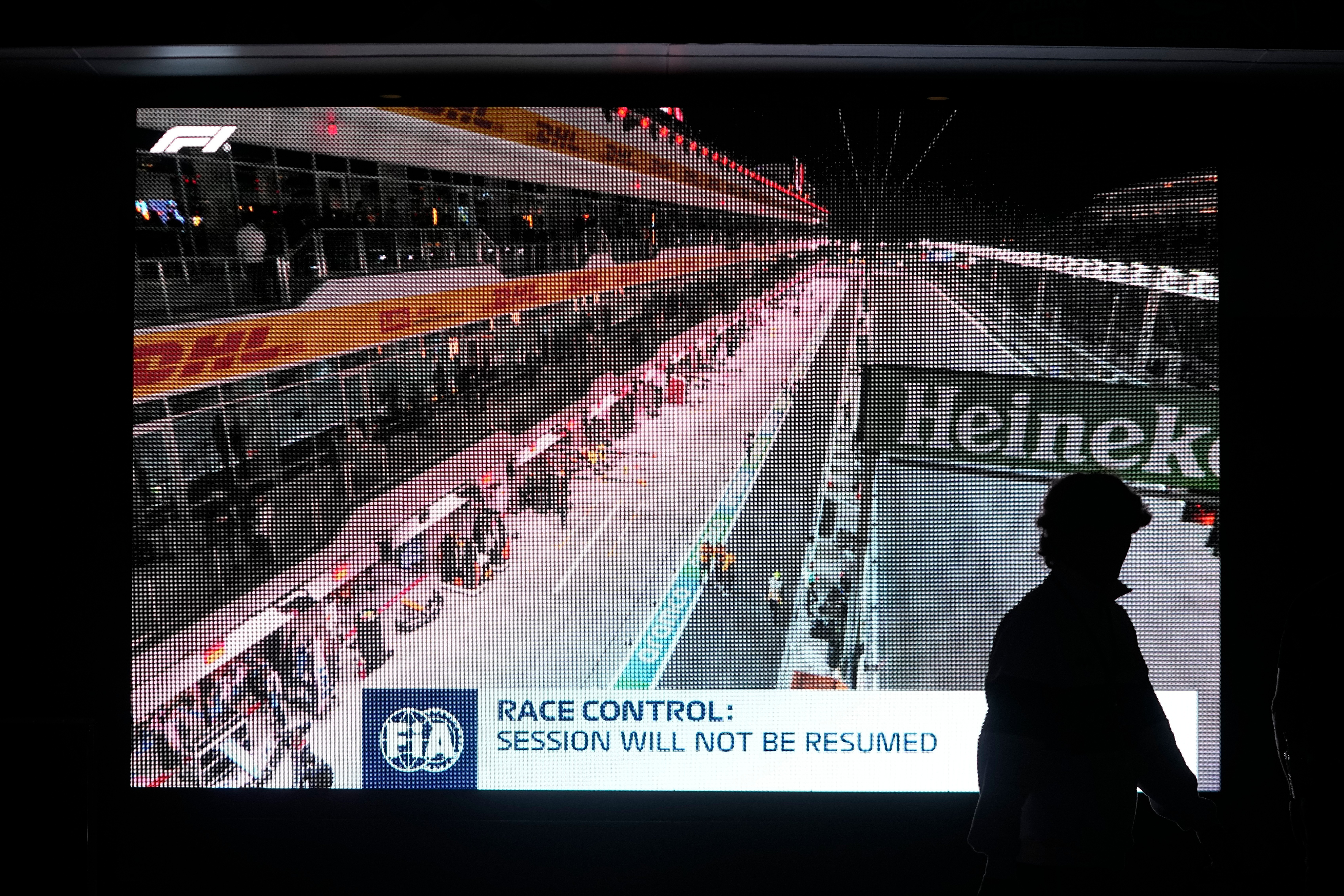 FILE - A fan walks pass a video board after the first practice session for the Formula One Las Vegas Grand Prix auto race was stopped, Thursday, Nov. 16, 2023, in Las Vegas. 