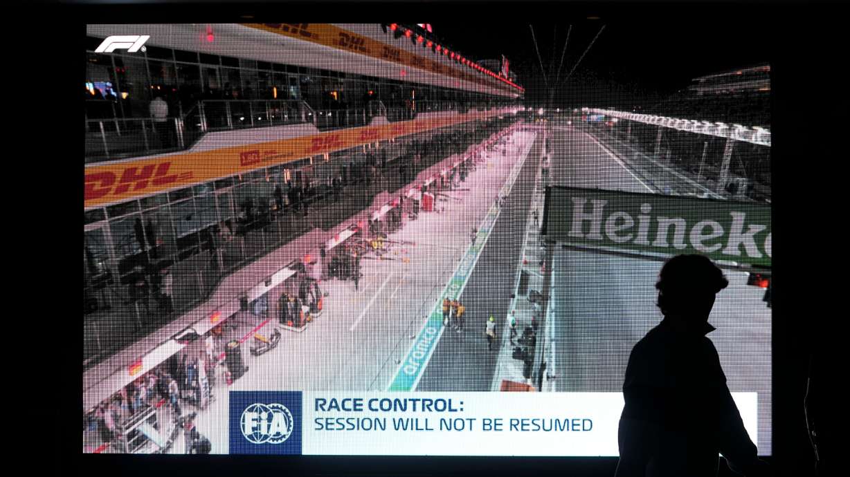 FILE - A fan walks pass a video board after the first practice session for the Formula One Las Vegas Grand Prix auto race was stopped, Thursday, Nov. 16, 2023, in Las Vegas.