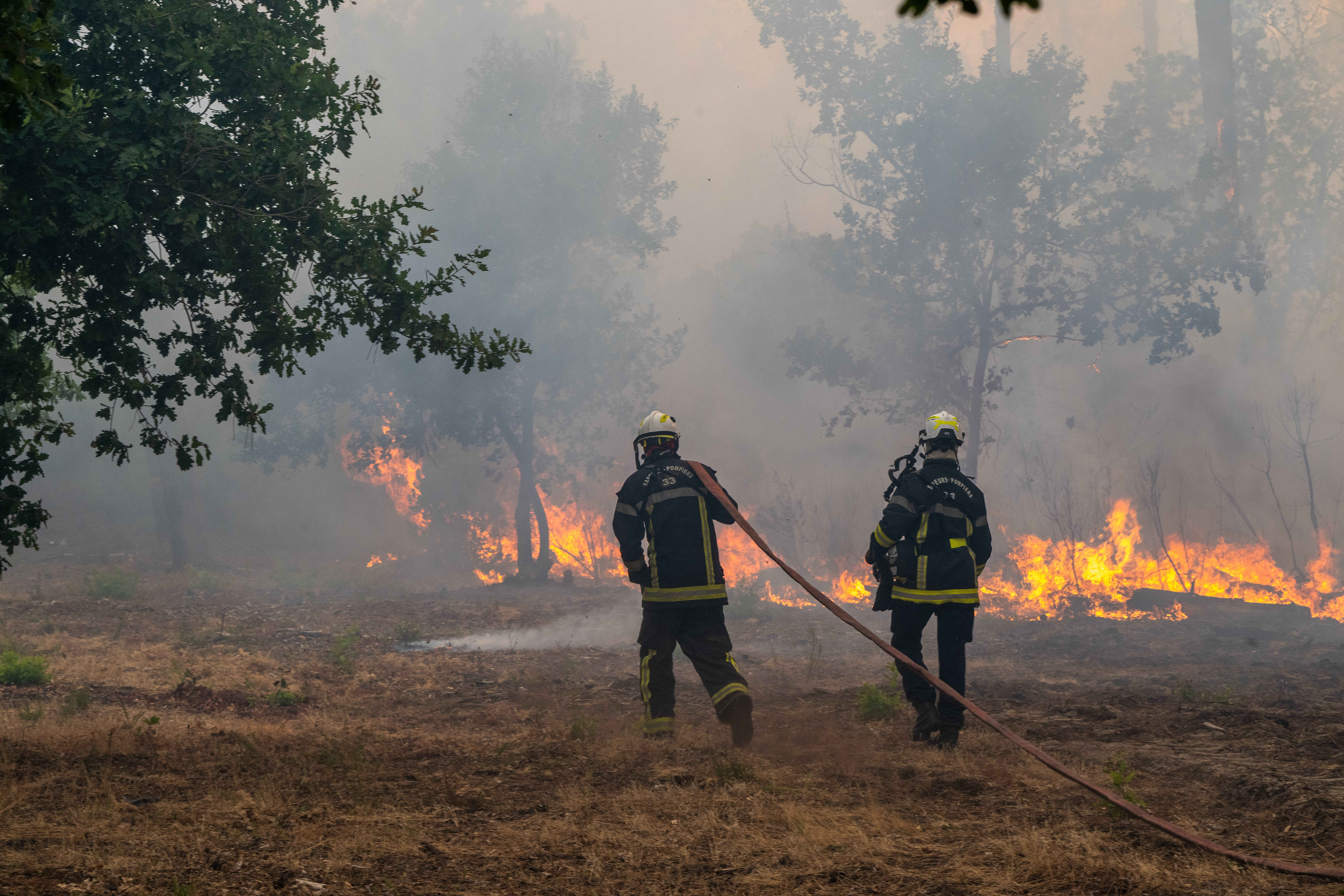 Fiirefighters spray water in a burning forest in the Lège-Cap-Ferret region, western France, on Friday.